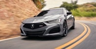 2025 Acura TLX Type S in Urban Gray Pearl 3/4 front view on the road. 2025 Acura TLX Type S in Urban Gray Pearl 3/4 front view on the road.