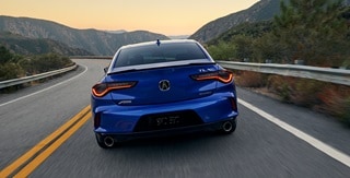 2025 Acura TLX A-Spec Package in Apex Blue Pearl rear view on the road. 2025 Acura TLX A-Spec Package in Apex Blue Pearl rear view on the road.
