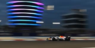 Visa Cash APP Racing Bulls Team vehicle on the rice track with buildings on the back Visa Cash APP Racing Bulls Team vehicle on the rice track with buildings on the back