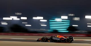Oracle Red Bull Racing Team vehicle on the rice track with a building with lights on the background Oracle Red Bull Racing Team vehicle on the rice track with a building with lights on the background