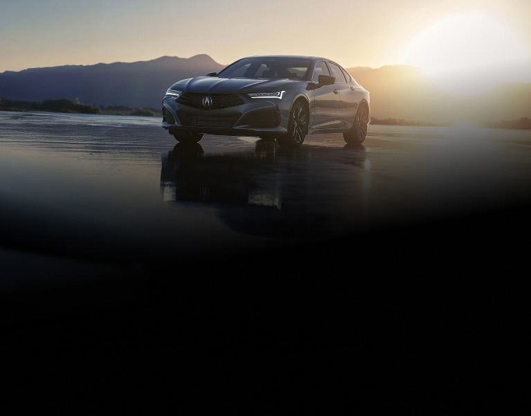 2026 Acura TLX with Technology Package in Liquid Carbon Metallic, front three-quarter view at sunset with mountains (Premium Sport Sedan). 2026 Acura TLX with Technology Package in Liquid Carbon Metallic, front three-quarter view at sunset with mountains (Premium Sport Sedan).